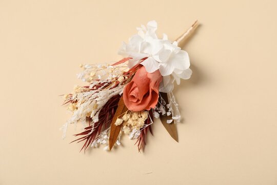 Stylish boutonniere on beige background, above view