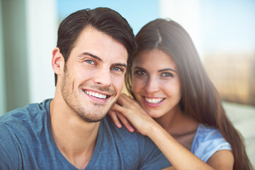 Happy, love and portrait of couple on sofa relaxing and bonding together in living room at home. Smile, romance and young man and woman with positive attitude resting in lounge at apartment.