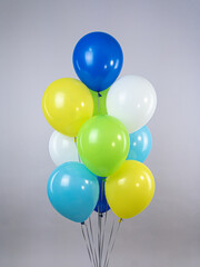Fountain of colorful air balloons of bright colors on a gray background