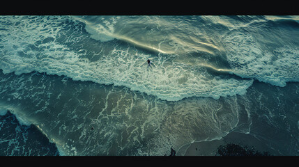 High view of waves on beach with person.