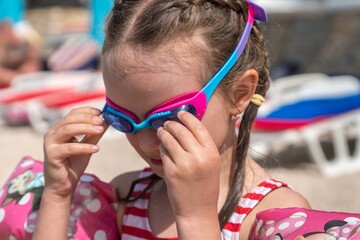 Child by the sea puts on her diving googles