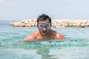 Man with diving mask in the sea, about to dive