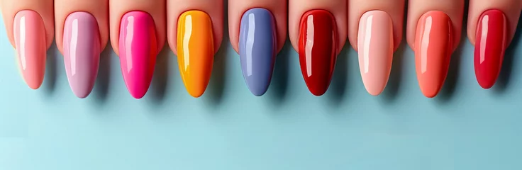 Different female nails with colourful manicure close up on blue background.