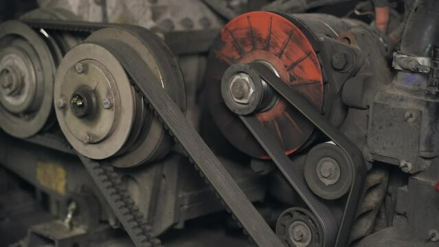 Detailed examination of the bus engine compartment, showing the engine with generator and the coordination of belts and pulleys.