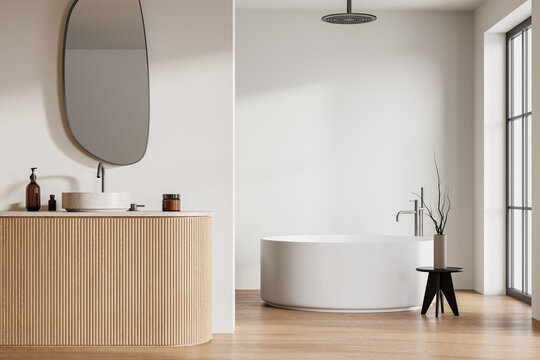 Modern hotel bathroom interior with sink, tub and panoramic window