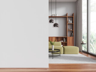 White living room interior with green couch and blank wall