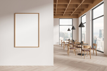 White restaurant interior with round tables and poster