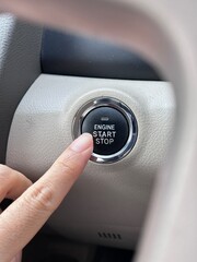 pushing blue power ignition button to start keyless ignition hybrid car engine
