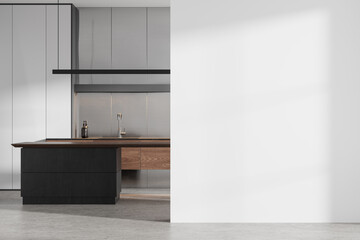 White kitchen interior with black island and blank wall