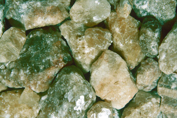 Rough stones of citrine quartz with green shade. Full surface. Concept of gemology, crystal therapy and geology.