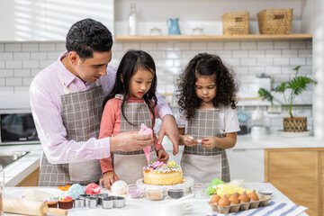 Naklejka premium Portrait of enjoy happy love asian family father with little asian girl daughter child play and having fun cooking food together with baking cookie and cake ingredient in kitchen
