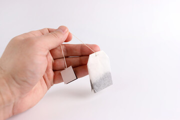 A tea bag is held in the hand. Preparation of fragrant tea.