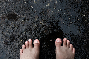 The foot stepping on a wet cement floor