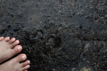 The foot stepping on a wet cement floor