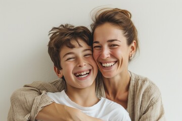 A woman and a boy smile and hug, sharing a happy gesture for the camera - obrazy, fototapety, plakaty