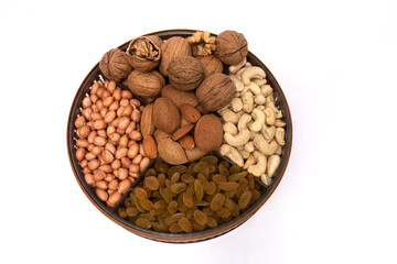 Nutritious Array: Assorted Nuts and Dried Fruits on a Round Tray, This image presents a round tray filled with a variety of nuts and dried fruits, neatly arranged in four sections.