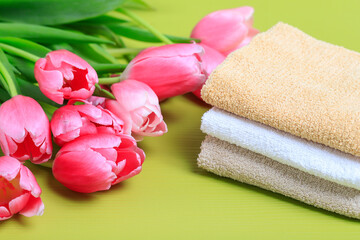 Obraz na płótnie Canvas Bouquet od pink tulips and soft towels on green background.