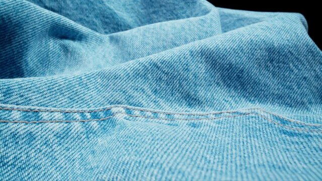 Fabric material. Denim jeans. Slider dolly shot with laowa probe lens. Fabric texture. Denim trousers. Close-up in 4K, UHD