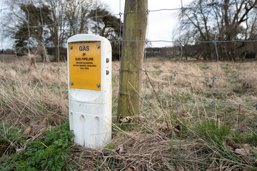 Shallow focus of a mains gas pipeline marker which shows the location of one of Britain's main trunk pipelines. No digging must take place in the pipeline area.