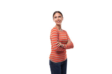 young pleasant caucasian woman with black hair dressed in a striped orange sweater posing on a white background with copy space