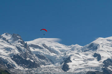 Red paragliding in flight over Mont Blanc (4808 m.), Chamonix, Haute Savoie, Rhone Alpes, France - obrazy, fototapety, plakaty