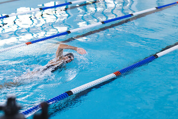 Swimmer in action at an indoor pool, with copy space