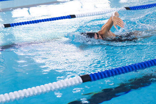 Caucasian female athlete swimmer swimming laps in a pool, with copy space