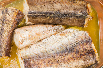 Hake pieces baked in glass pan, top view close-up