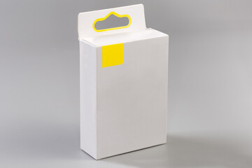 White rectangular cardboard hang tab packing box on gray surface