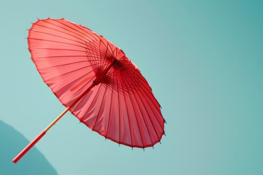 Red umbrella on blue sky background, vintage color tone and soft focus.