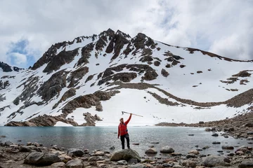 Papier Peint photo autocollant Fitz Roy Excursionista alzando su bastón en señal de éxito por subir hasta la Laguna de Los Tres, en el Chalten, Patagonia