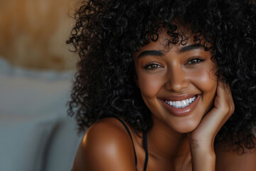 Woman with curly hair smiling on bed, suitable for lifestyle and relaxation concepts