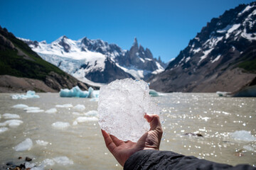 Turista mostrando a cámara un bloque de hielo del glaciar Torre, en el Chalten, Argentina