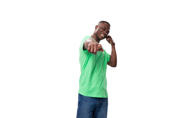 Fototapeta premium young stylish american man in casual t-shirt and jeans points with his hand on a white background