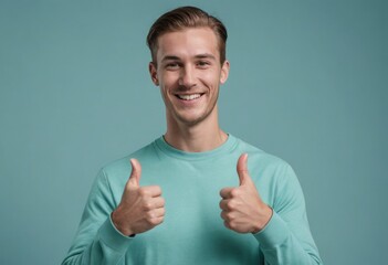 A cheerful man in a light teal sweater giving two thumbs up with a bright and friendly smile.