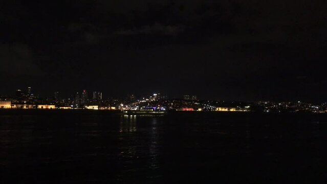 A walk down the Bosporus at night towards the 15 July Martyrs Bridge (15 Temmuz Şehitler K&ouml;pr&uuml;s&uuml;) at night. The skyline is dotted with lights from buildings on the opposite shore and ships passing. 