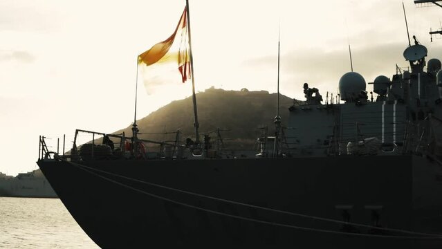 warships at anchor in the bay at sunset