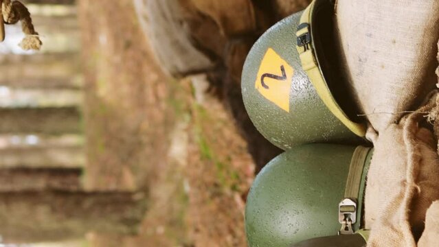 WWII American Metal Helmets Of United States Army Infantry Soldier At World War II. Helmets Near Camping Tent In Forest Camp.
