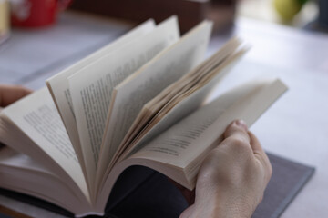 Men's hands flipping through the pages of the book. Close up view.