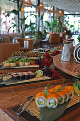 Various types of sushi lined up on a buffet for an event