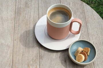 Coffee and cookies on a wooden table in the garden