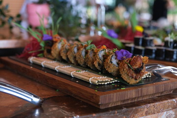 Various types of sushi lined up on a buffet for an event