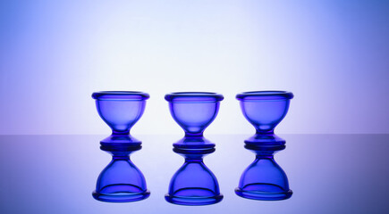 Elegant blue glass tableware on softly glowing gradient backdrop