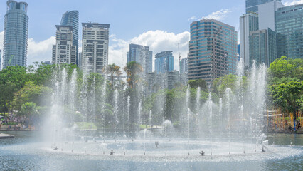 31 December 2023 in Malaysia A photo of a fountain dancing in a park. There is greenness among the...