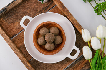 Fresh home made urad dal and millet laddu isolated and decorated. Locally called Urad Dal Ladoo, Ulundu urundan, Ulundu laddu, Kambu laddu. Selective focused millet ladoo.