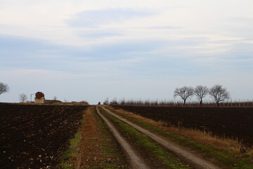A dirt road with a tower in the distance