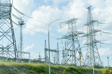 High voltage towers with sky background. Power line support with wires for electricity transmission. High voltage grid tower with wire cable at distribution station. Energy industry, energy saving