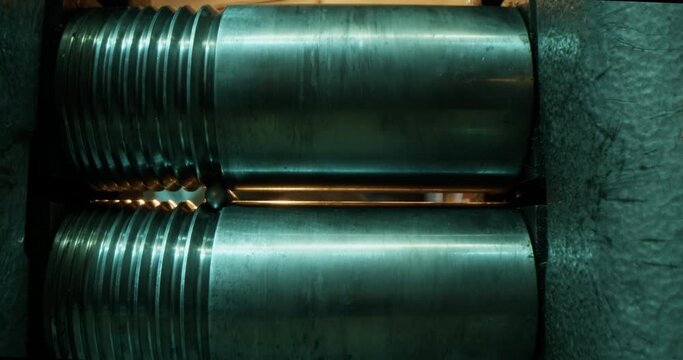 Jeweler rolling silver stick through rolling mill