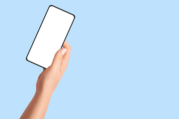 Female hand holding phone with blank screen on blue background