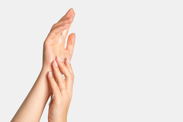 Women's hands in flowing gel, spreading over their hands. On a light background